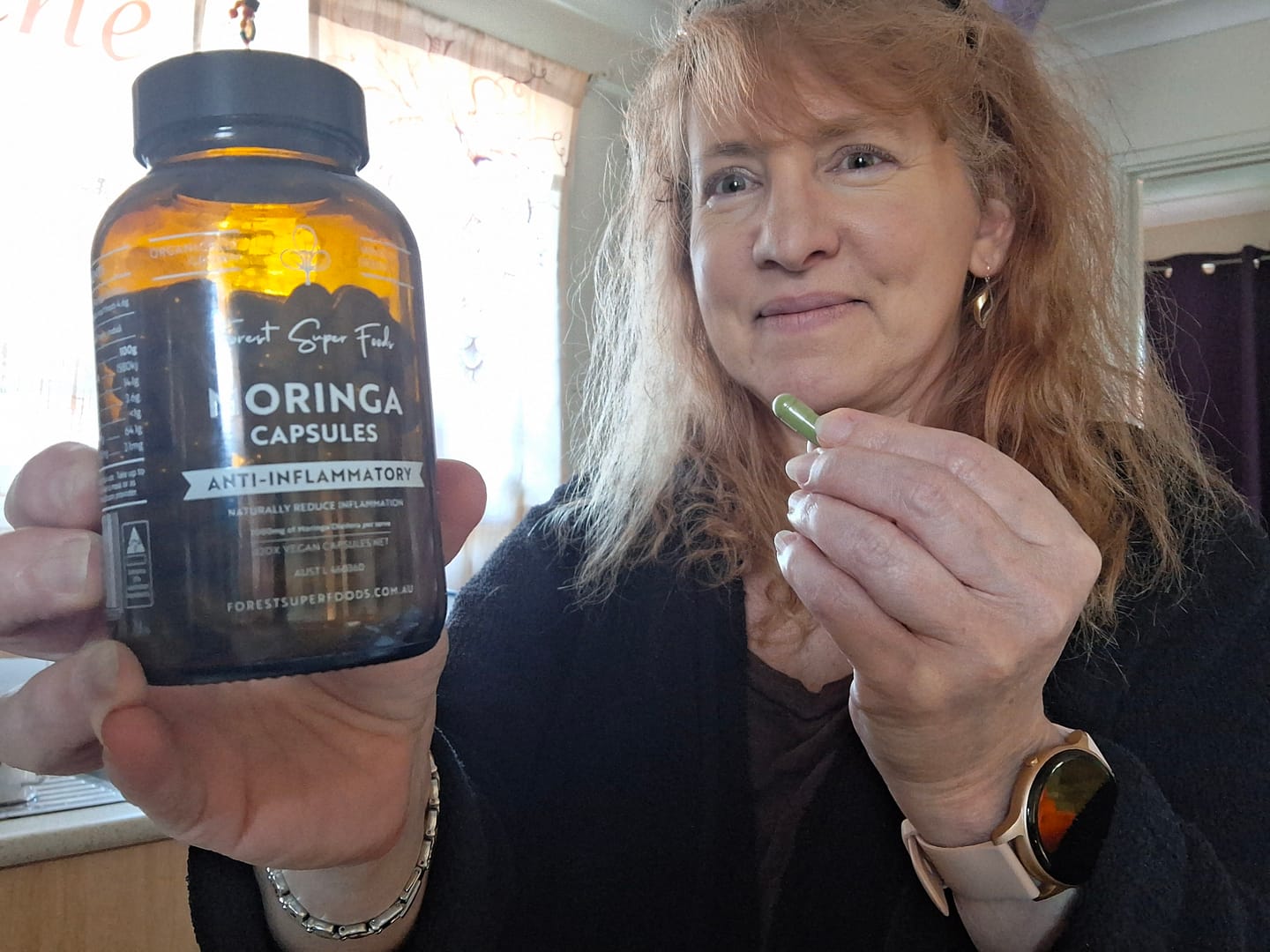 Customer holding a bottle of Forest Super Foods Moringa Capsules.